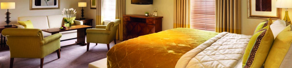A picture of a beautiful hotel room decorated in creams and golds, at the Arden Hotel.